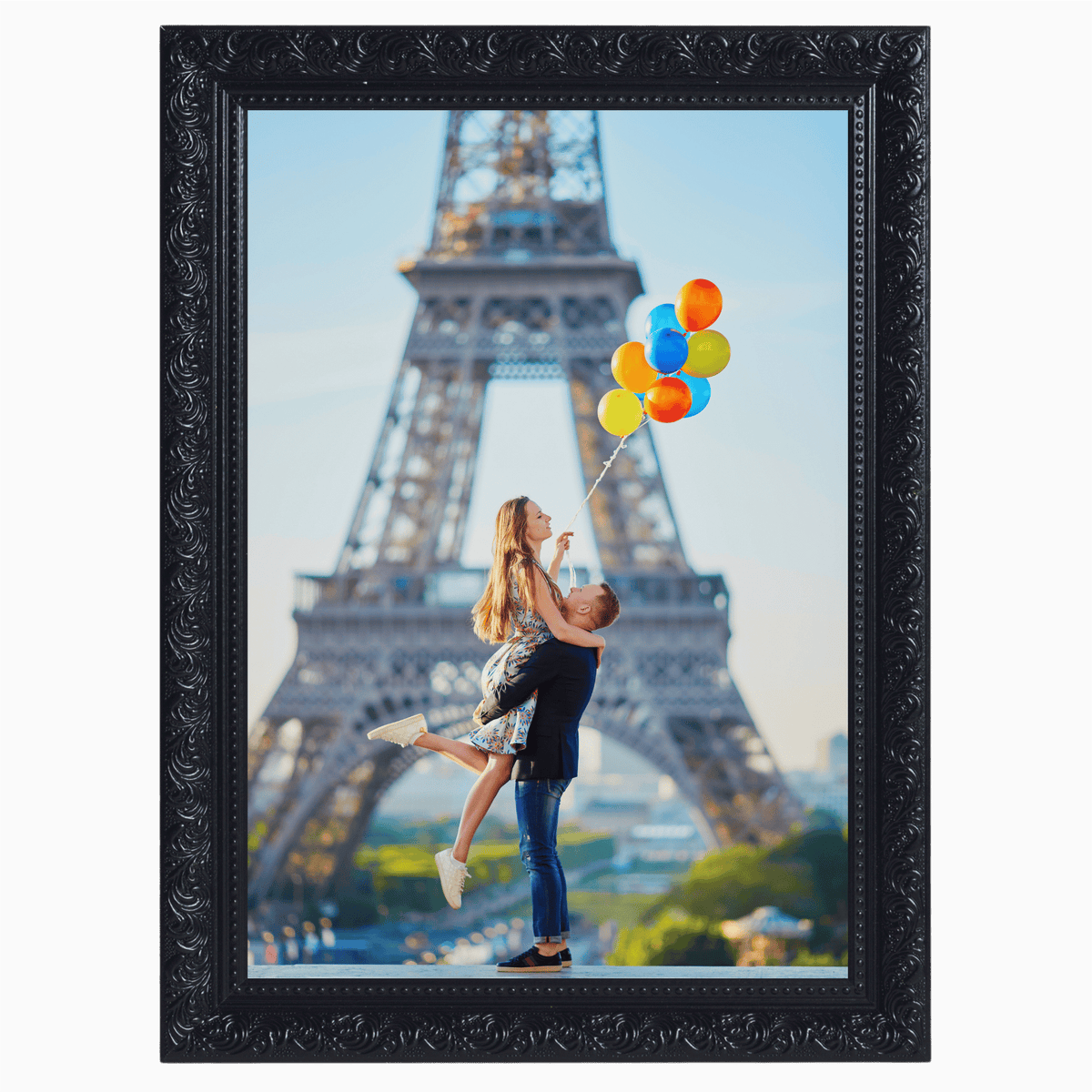 A couple joyfully celebrating with colorful balloons in front of the Eiffel Tower.
