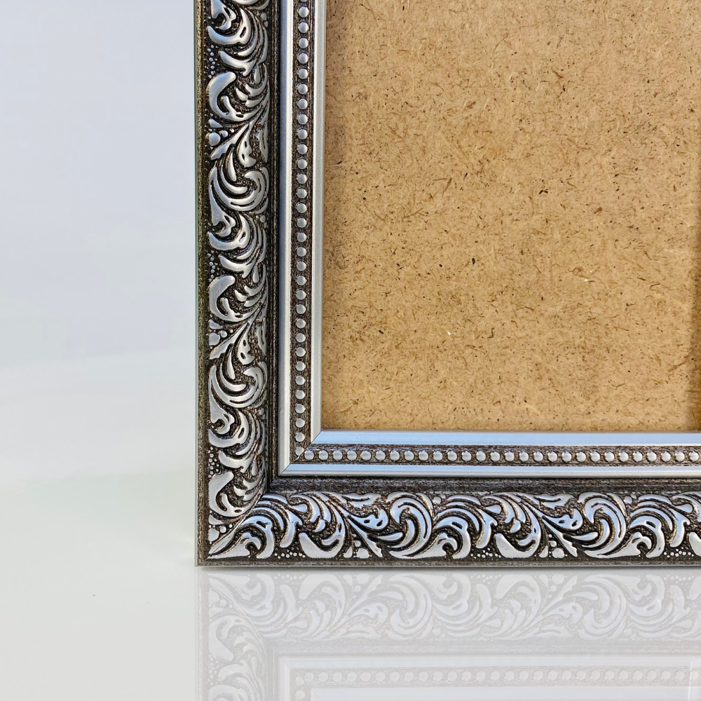 Intricately designed silver photo frame with a blank backing